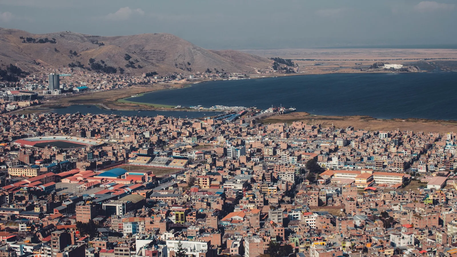 Vue panoramique sur Puno et le lac Titicaca depuis les hauteurs de l'Altiplano péruvien au coucher du soleil