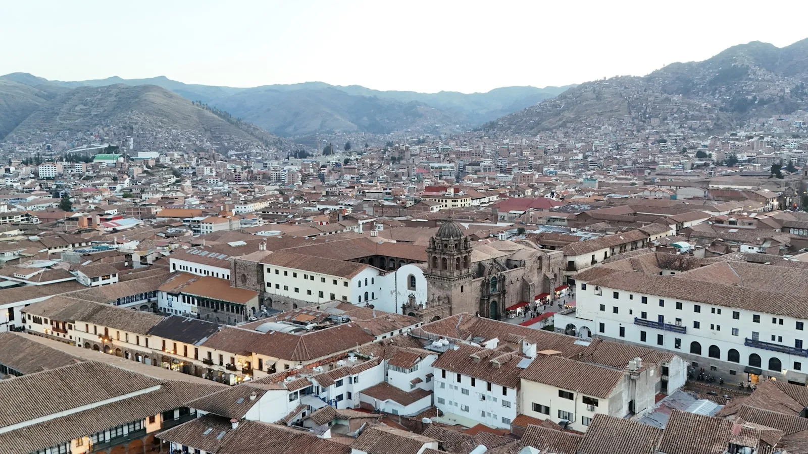 Vue panoramique sur Cusco et ses toits de tuiles ocre dominés par la forteresse de Sacsayhuamán et les Andes enneigées