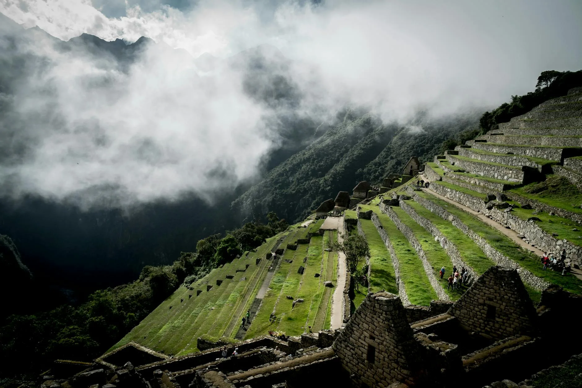 La cité inca de Machu Picchu baignée de nuages matinaux, terrasses agricoles et montagnes andines en arrière-plan